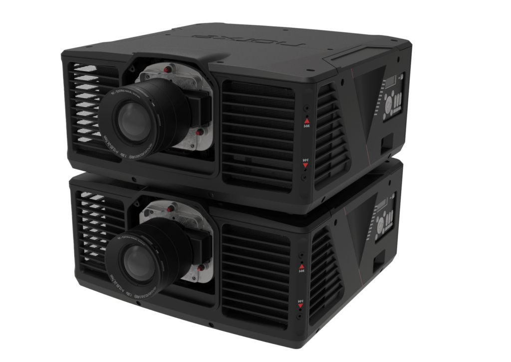 Two stacked high-performance projectors in black casing with large central lenses and vented sides, reflected on a glossy surface.