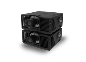 Two stacked high-performance projectors in black casing with large central lenses and vented sides, reflected on a glossy surface.